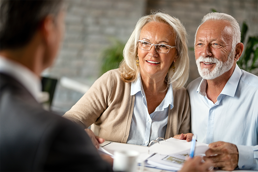 Senior male and female with silver hair, meeting with lawyer to setup estate and trust